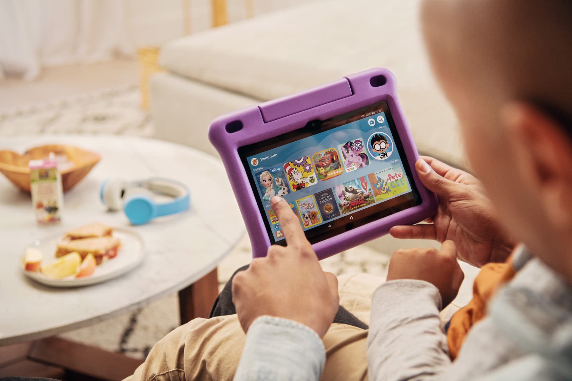 Parent and child browsing Amazon Kids on a purple Fire HD 8 Kids Edition tablet in a living room