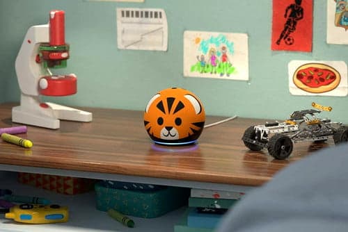 Echo Dot Kids Edition Tiger on a child's desk with art on the wall, a microscope, and toy car